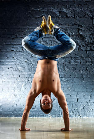 Young strong man standing on hands.