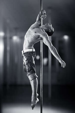 Young strong pole dance man の写真素材