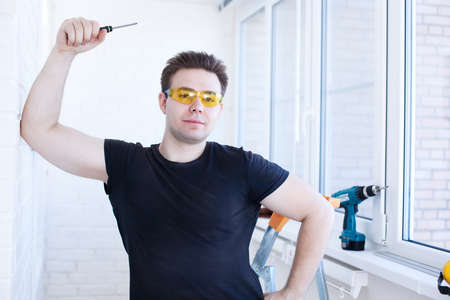 Man worker with screwdriver on balcony の写真素材