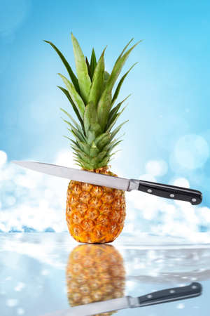Pineapple and cutting knife on blue background.の写真素材