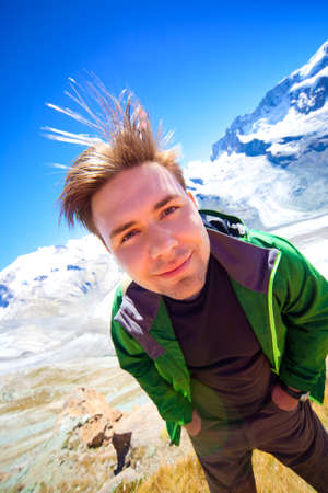 Young smiling man on mountains background.