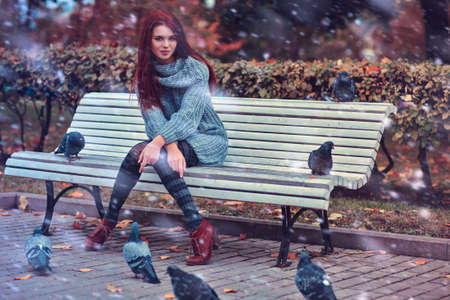 Young woman in park sitting on bench.の写真素材