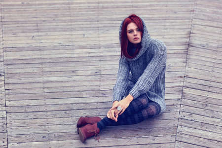 Young slim woman sitting outdoors の写真素材