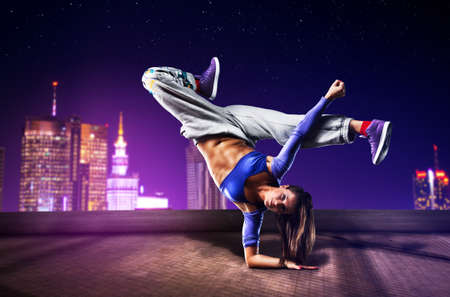 Young woman dancing on city background.の写真素材