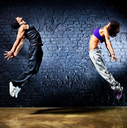 Young dancer couple jumping  On wall background の写真素材