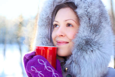 Young woman with warm mug winter portrait.
