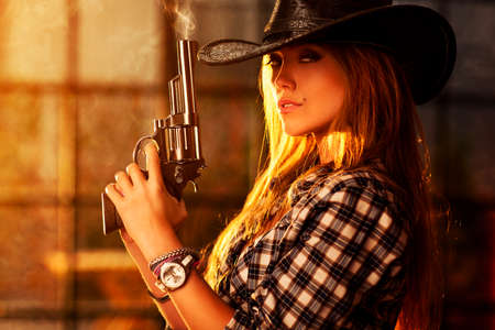Young woman with gun portrait.の写真素材