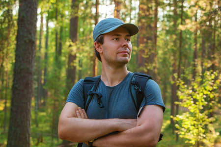 Young man tourist in cap and t-shirt portrait on forest background.の写真素材