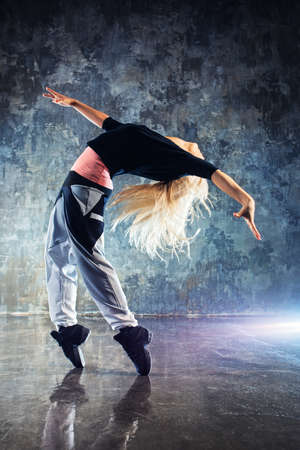 Young woman modern dancer. On stone wall background.の写真素材
