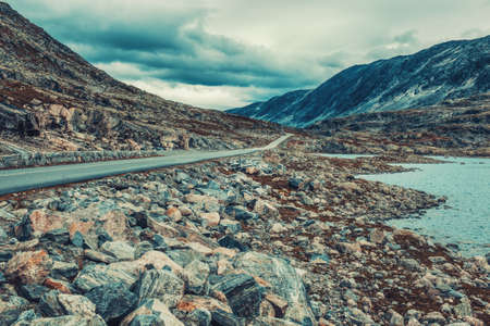 Norway high mountains landscape with road and lake. Film style colors.の写真素材