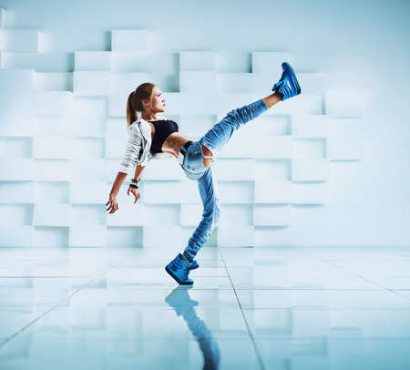 Young sexy woman modern dancer with tattoo on body in white and blue interiorの写真素材