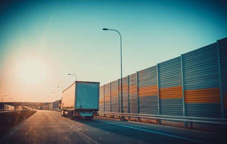 Road perspective. Photo from front car glass at sunset light with flares. Traveling mood concept.