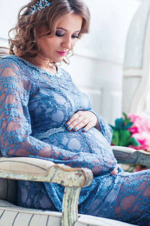 Young pregnant woman indoors portraitの写真素材