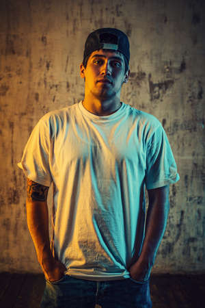Young man breakdancer portrait with cold and warm lights. Tattoo on body.