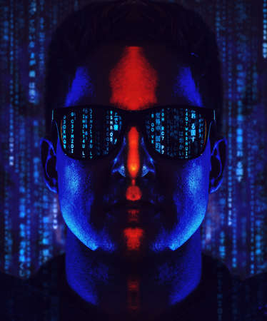 Young cool man program coder in sunglasses portrait. Contrast dramatic blue and red colors and code...