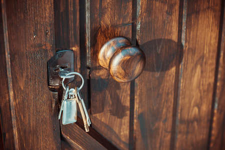 Handle and keys in lock of wooden door of fenceの写真素材