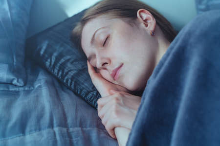 Young woman sleeping at home in bed