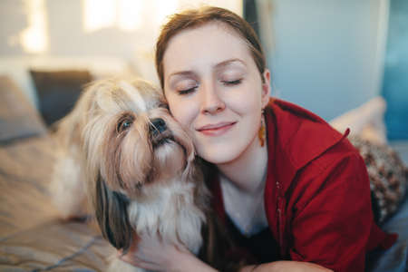 Young woman with shih tzu dog portrait. Love and care to pet concept.の写真素材