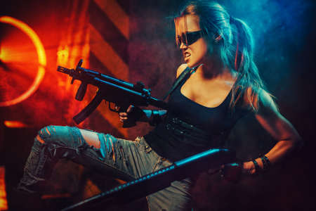 Young strong woman warrior with big guns in dramatic urban night scene