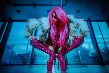 Young sexy woman pole dancer with pink hair portraitの写真素材