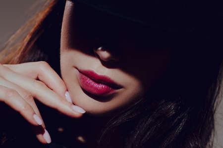 Woman stranger in hat and shadow on face close-up portrait