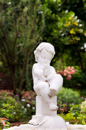Beautiful Cherub statue profile in the Gardenの写真素材