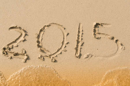happy new year 2015  on sandy beach with waveの写真素材