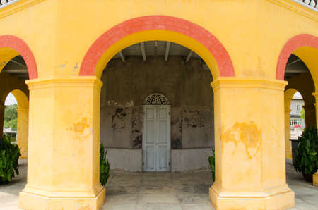 old wooden door orange wall background with stoned frameの写真素材