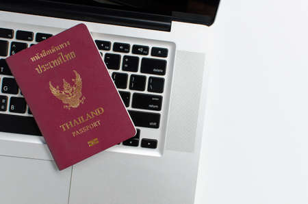 Thailand passport with laptop on white background, Find travel informationの写真素材