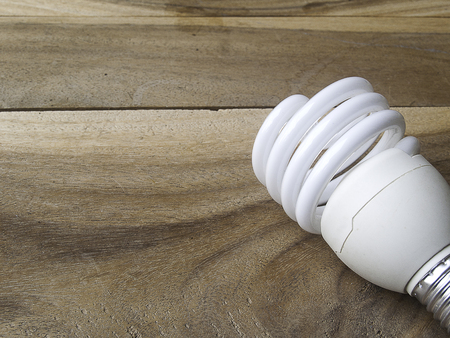 energy saving light bulb on old wooden background
