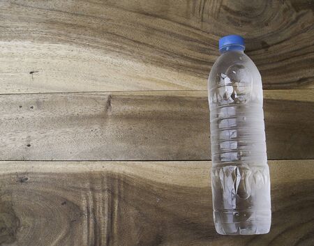 Drink water bottle on a old wooden background,plastic bottleの写真素材