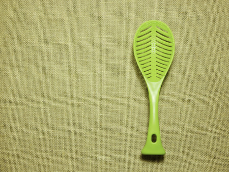 green plastic ladle on brown Hessian sackcloth woven texture background,copy space from your textの写真素材