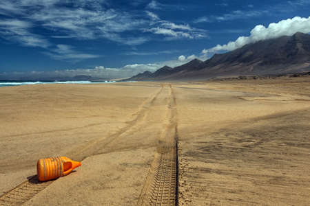 orange bottle on sandの写真素材