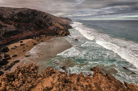 Hiking path through the sandy mountains. In the background the beach of Cofete.