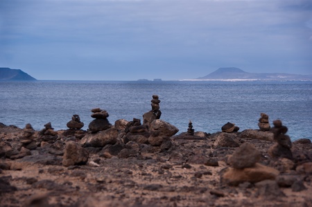 rock piles in playa blanca with fuerteventura island in the backgroundの写真素材