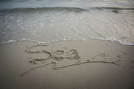 Sea Message in Smooth Sand with Waveの写真素材