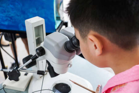 Close-up of a male student using microscopeの写真素材