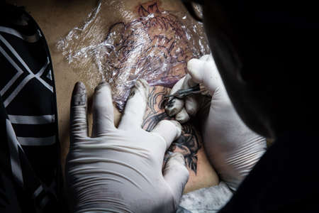 tattooer showing process of making a tattoo. Tattoo design in pattern