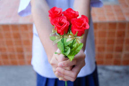 Hand holding bouquet of red rosesの写真素材