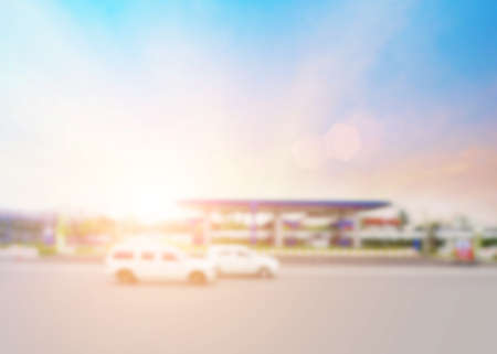 Blurred background of oil petrol station daytime with car and colorful sunset.の写真素材