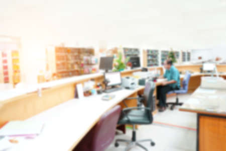 Abstract blurred background with many bookshelves in library at university.