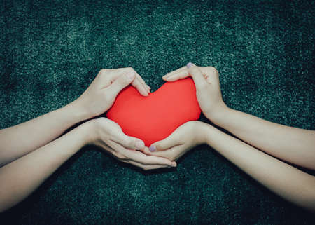Young man giving a heart-shaped pillow his sweetheart on Valentine's Day. Love beautiful concept
