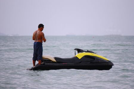 Pattaya City,Bangkok- June 2012- A man with tattoo is standing on jet ski