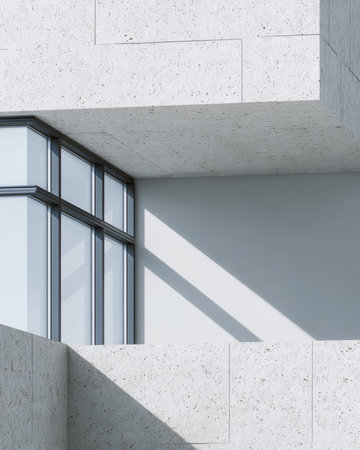The scene showcases a contemporary building with sleek lines, expansive glass windows, and textured stone walls. Light and shadow emphasize the unique geometry.の素材