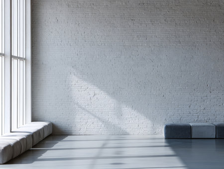 This indoor area features a spacious layout with large windows allowing natural light to fill the room. The gray walls and soft seating create a calm and modern atmosphere.の素材