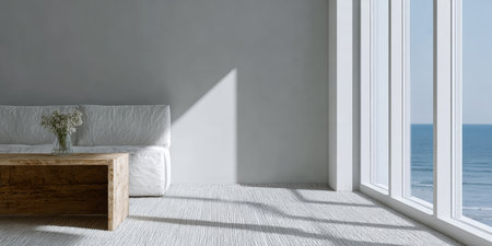Bright living room features a cozy white sofa and a wooden coffee table. Large windows showcase a stunning ocean view and let in warm sunlight, creating a serene atmosphere.の素材