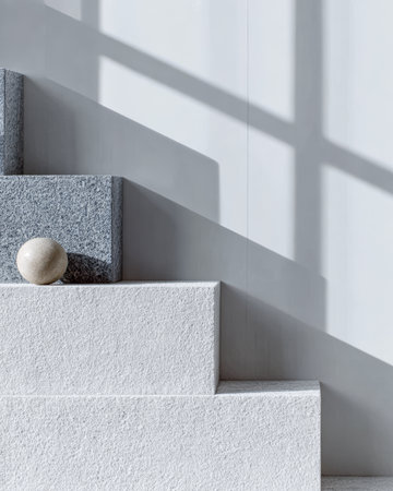 Smooth stones are carefully placed on minimalist stairs, showcasing a blend of textures. Natural light filters through, creating interesting shadows on the surface in a contemporary setting.の素材