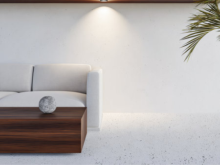 A sleek living room showcases a comfortable white couch paired with a dark wooden coffee table. Soft lighting highlights the minimalist decor, creating a calm atmosphere.の素材