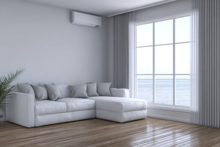 Bright living room features a spacious white couch with pillows, large window offering ocean views, and light wooden flooring, creating a serene atmosphere.の素材