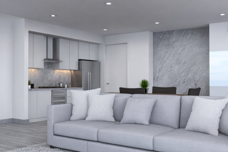 Spacious living room with a gray sofa, located next to a stylish kitchen in a contemporary coastal apartment. Bright light fills the area, emphasizing the chic decor.の素材